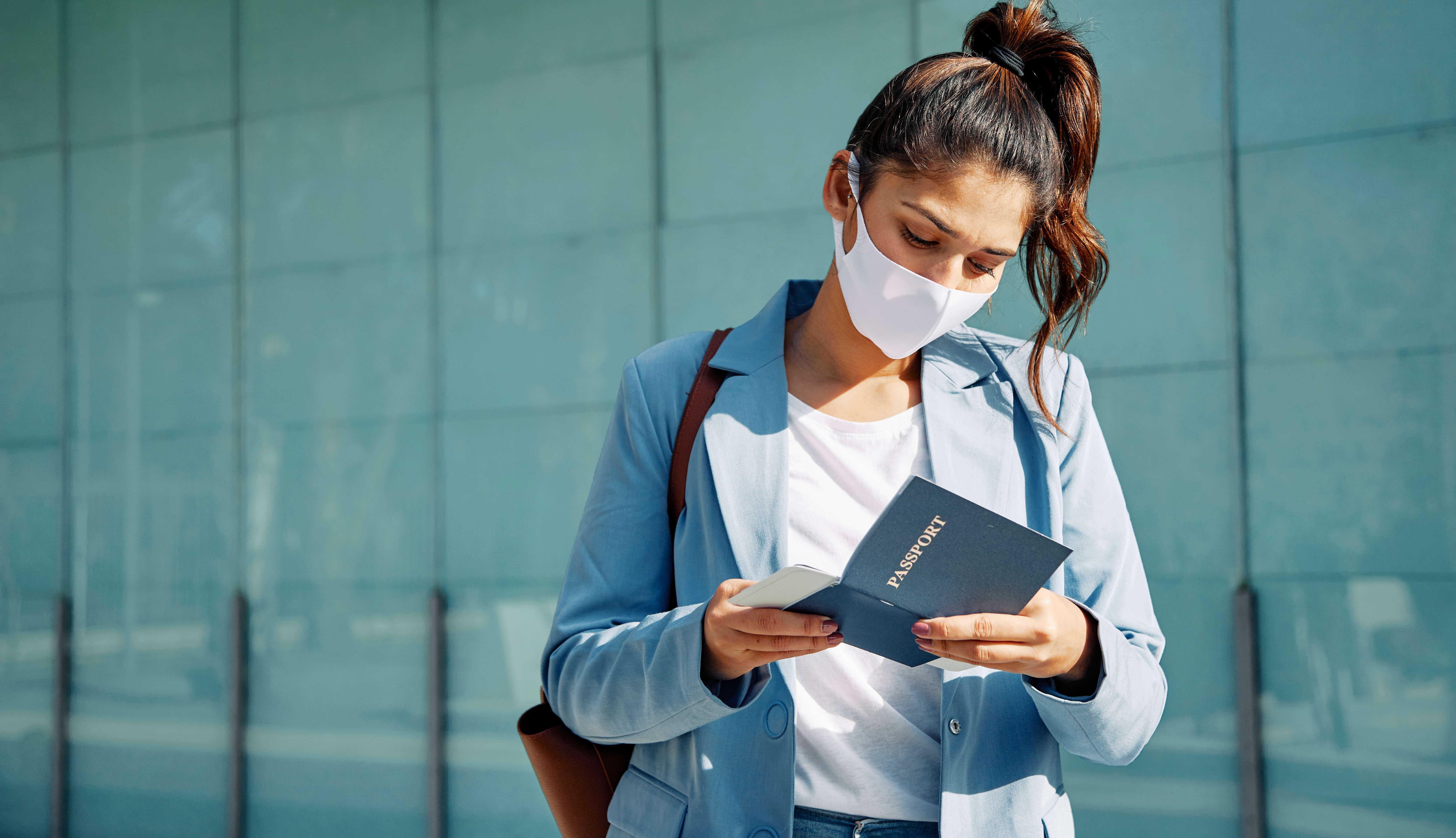 woman-with-medical-mask-checking-her-passport-airport-during-pandemic