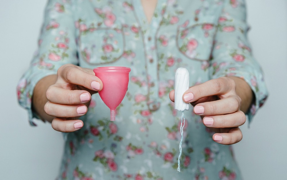 Woman,Hands,Comparing,Menstrual,Cup,With,A,Tampon