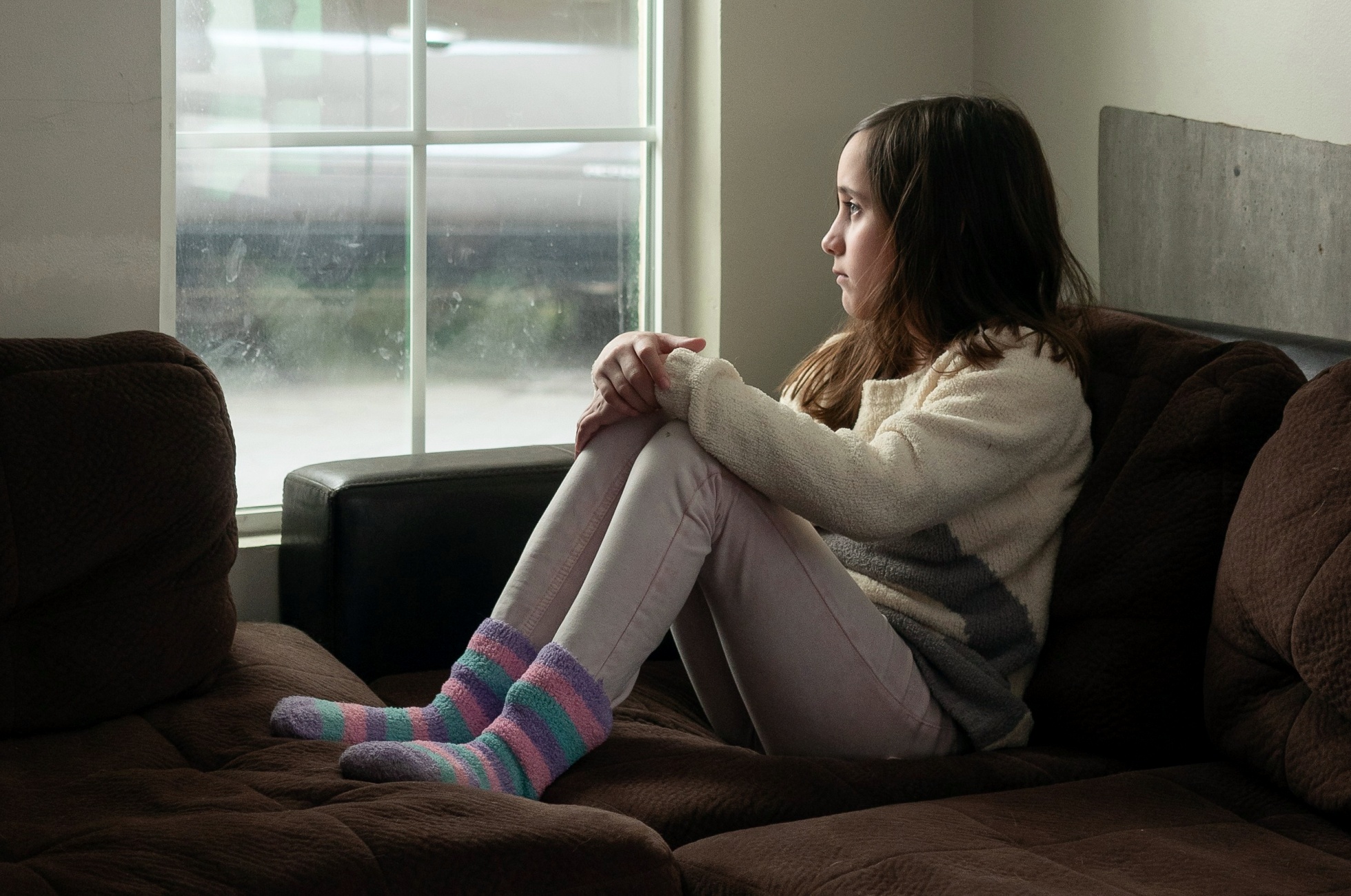 Smutné dítě vyhlíží z okna